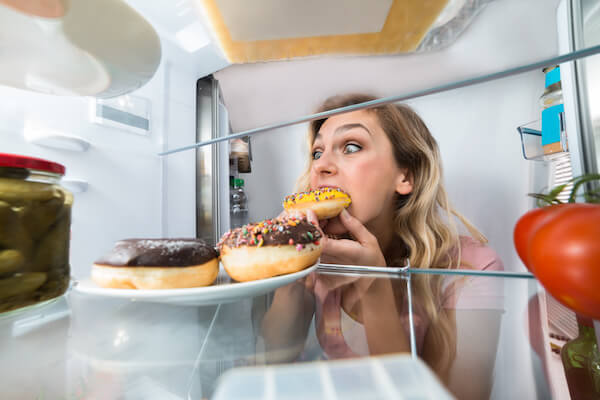 Woman Eating From Fridge